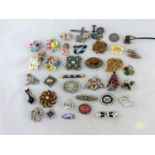 A large selection of costume jewellery brooches (some stones missing)