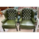 A pair of gentleman's leather wing back armchairs with deep button backs, studded borders in