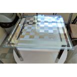 A mirrored effect chess top coffee table and two folding chairs