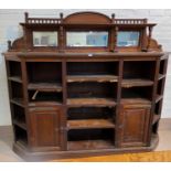 An Edwardian large bookcase/side cabinet with low raised mirror back, 4 canted shelves to each