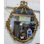 An oval wall mirror in gilt metal rococo style frame, 55 cm overall; a gilt framed oil on canvas