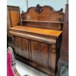 A Victorian figured mahogany chiffonier with carved arched back and raised shelf over frieze