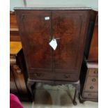 A reproduction burr walnut cocktail cabinet enclosed by 2 doors and drawer under, on cabriole legs