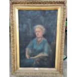 A large gilt framed oil painting of a woman seated