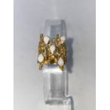A 1960's/70's modernist yellow metal dress ring, pierced bark effect set 5 opal coloured stones,