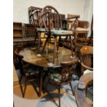 An Ercol dark oak dining suite comprising drop leaf circular table and 4 fleur de lys chairs, 2