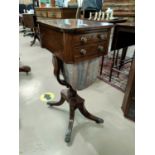 A Regency period rosewood work table with brass inlay, of rounded rectangular form having 2