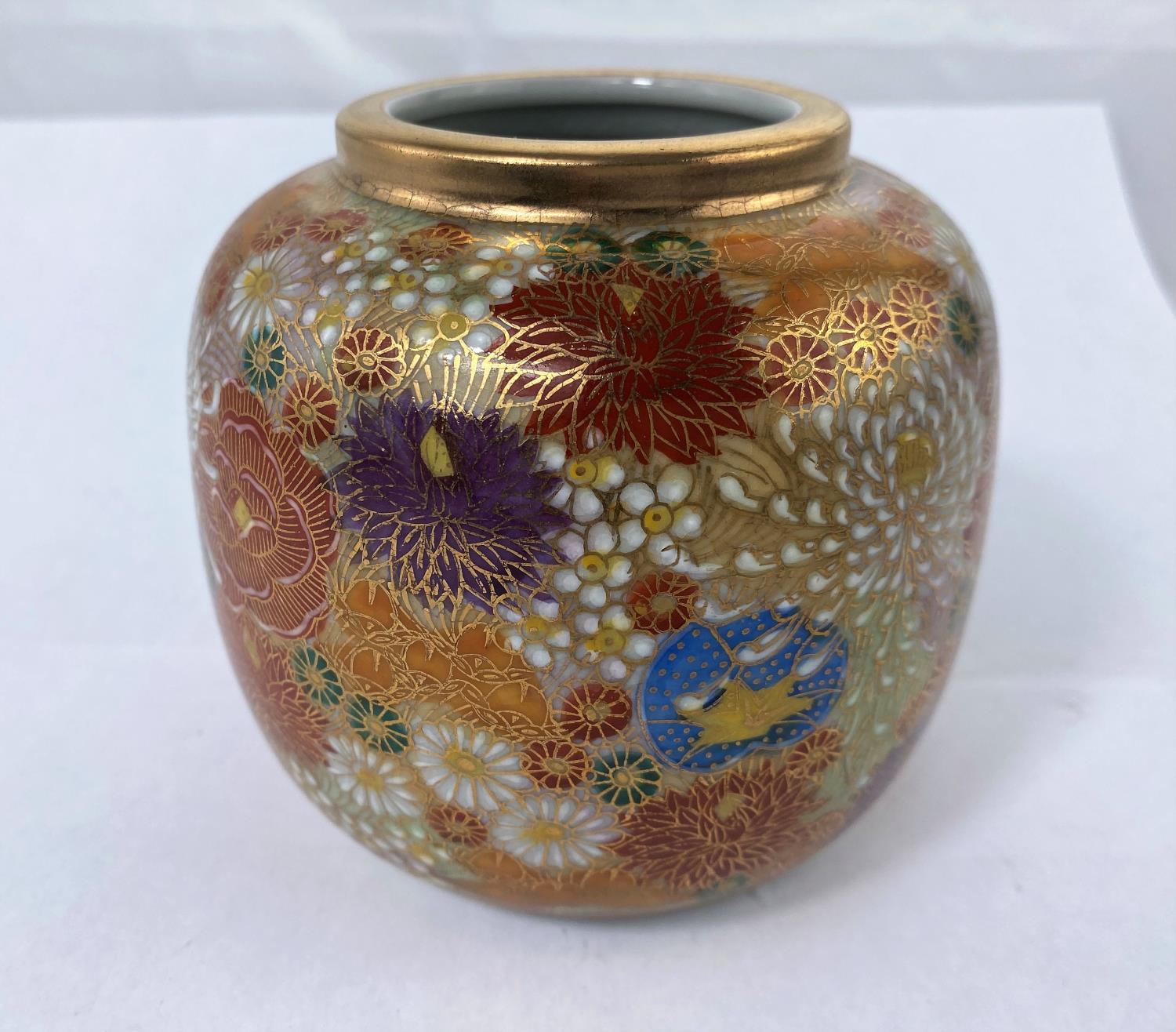 A Japanese jar with detailed floral decoration with gilt highlight and rim with signature to base,