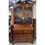 A George III mahogany bureau with fall front enclosing central boxwood inlaid cupboard door