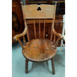 A late 19th / early 20th century fireside armchair with solid round seat, stick back and turned legs