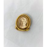 A Victorian gilt metal oval brooch with central swivel double sided photo miniatures