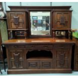 A late Victorian carved oak sideboard in the Arts & Crafts style, the raised mirror back with twin
