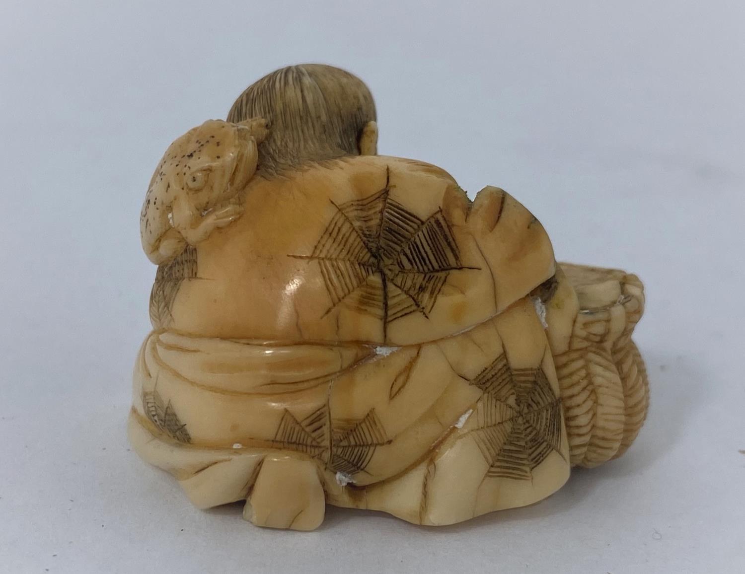 A Japanese netsuke, man reclining with frog on back, missing one arm - Image 3 of 5