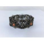 A white metal filigree bracelet set with coral