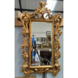 A 19th century rectangular bevelled edge wall mirror in carved and gilded Florentine style frame,