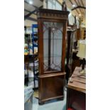 A reproduction full length corner display cabinet in mahogany, with glazed and panelled doors, on