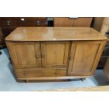 A 1960's Ercol elm sideboard with 3 cupboards and drawer