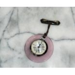 A mid century brooch fob watch with pink lucite surrounding