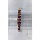 An Edwardian 9 carat hallmarked gold hinged bracelet set 9 graduating oval amethysts, 5.1 gm (