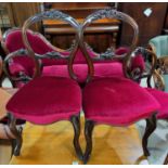 A Victorian set of 5 rosewood dining chairs, with balloon backs, foliate carved top rails and bar