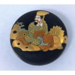 A Japanese satsuma miniature circular ceramic lidded pot decorated with traditional dressed man with
