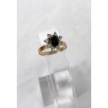 A 1970's dress ring set green topaz surrounded by clear stones in flower head setting, stamped '