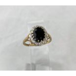 A 9ct gold dress ring set with large sapphire stone surrounded by diamond chips 3.6gms size