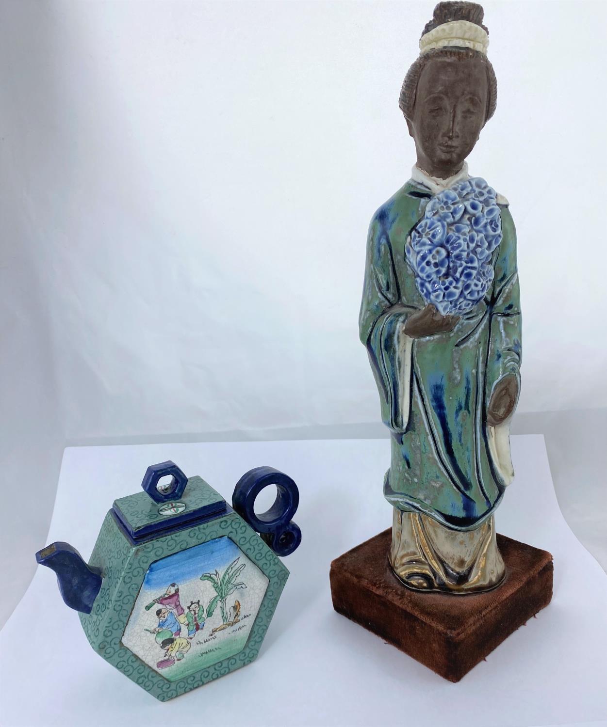 A Chinese ceramic figure of woman in robed and flowers, mounted on velvet stand, height 35cm and