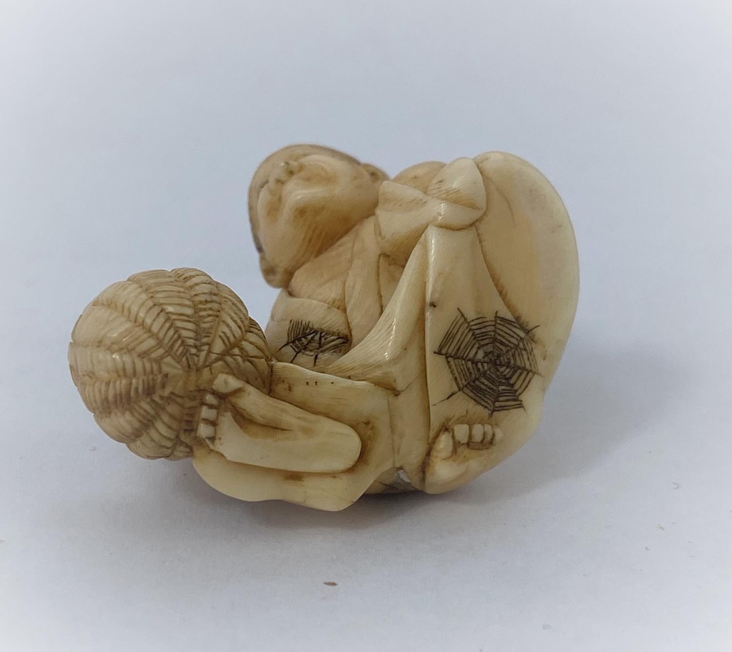 A Japanese netsuke, man reclining with frog on back, missing one arm - Image 5 of 5