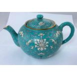 A Chinese ceramic turquoise teapot with stylized floral decoration, gilt highlights, seal mark to