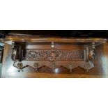 A carved oak reproduction wall shelf/coat rack in the French manner length 84cm