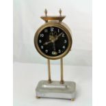 A "gravity" clock in circular brass case, on stainless steel base, height 26.5 cm