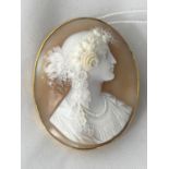 A Victorian shell cameo oval brooch depicting head and shoulders of a young woman with flowers in