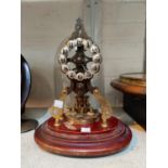 A 400 day brass skeleton clock with silvered individual numerals, under glass dome on mahogany