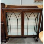 An early 20th century mahogany double door display cabinet on ball and claw feet