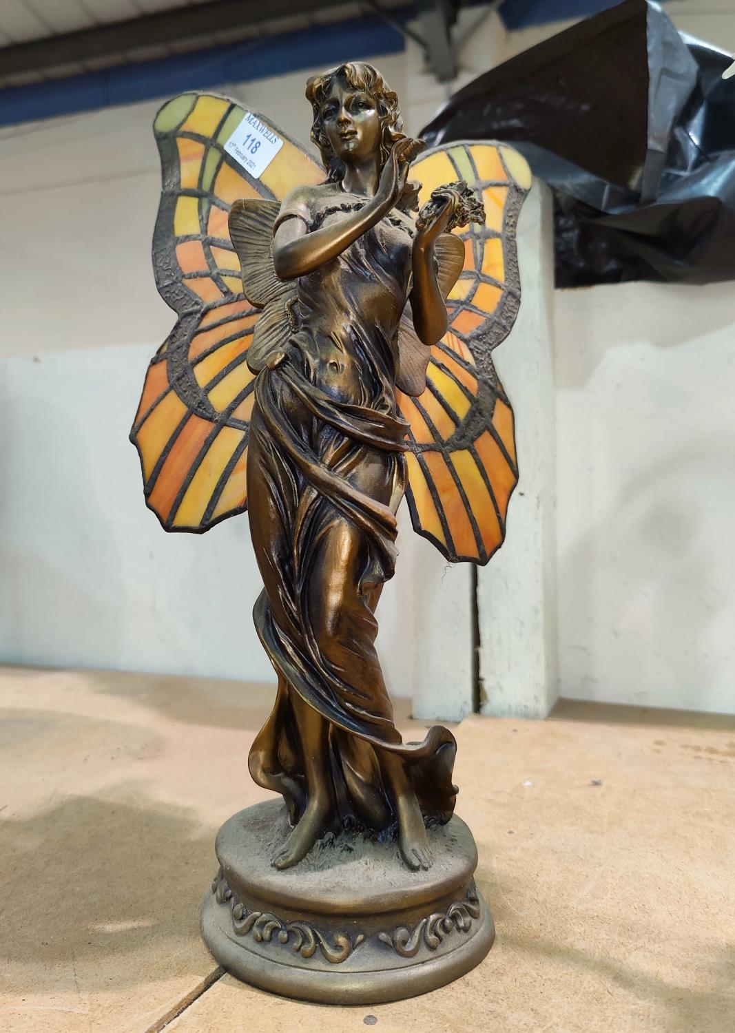 An Art Nouveau style table lamp in the form of a bronze fairy with coloured and leaded butterfly