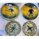 A pair of majolica dishes decorated with men holding clubs, diameter 24 cm (1 broken and glued); a