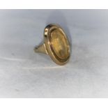 A gold men's dress ring set with an elongated oval pale yellow stone, stamped 9Kt 3.3gms