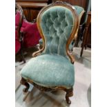 A Victorian walnut nursing chair with spoon back, on knurled cabriole legs, in sea green upholstery