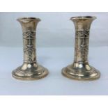 A pair of hallmarked silver candlesticks with classical relief decoration, height 9cm (weighted)