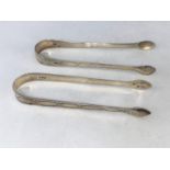 A pair of Georgian bright cut silver sugar tongs, Peter and Anne Bateman, London, and another