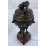 An oriental bronze censor of rounded form with three feet attached to base with Dog of Fo on top,