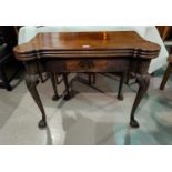 An early/mid Georgian mahogany card table with triple folding top and outset rounded corners, frieze