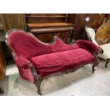 A Victorian rosewood framed chaise longue with foliate carved rails and uprights, on scroll carved