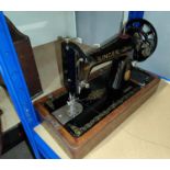 A Singer hand operated sewing machine in oak case