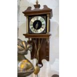 A reproduction wall hanging clock in mahogany case with double hanging weights
