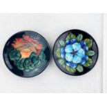 2 circular Moorcroft pin dishes decorated with blue flowers & leaves, orange flower & fruit