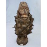 An African tribal carved wood and nail fetish figure with intertwined fabric 29cm