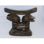 A Central African Luba tribal carved wood neck rest, the support in the form of embracing figures,