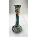 A Moorcroft vase with squat body & tall slender neck decorated with a peacock impressed &